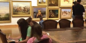 children completing worksheets during a field trip to a Denver art museum