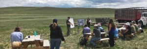 art writing instructors showing paintings to students on a Colorado plain